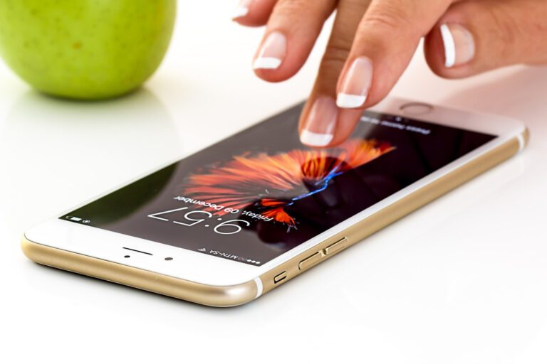 A woman is about to unlock her smartphone, which is sitting face-up on a table.