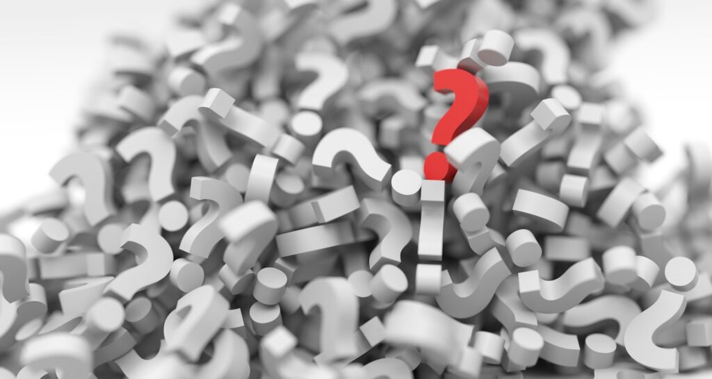One red question mark sits on top of a huge pile of white question marks.